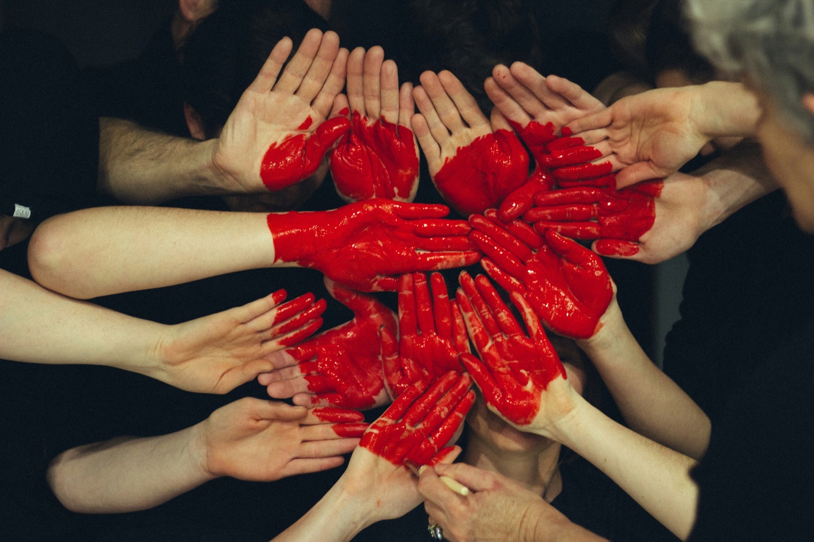 Volunteers place their painted hands together to form a red heart — the community causes UKNode sponsors with free UK hosting.