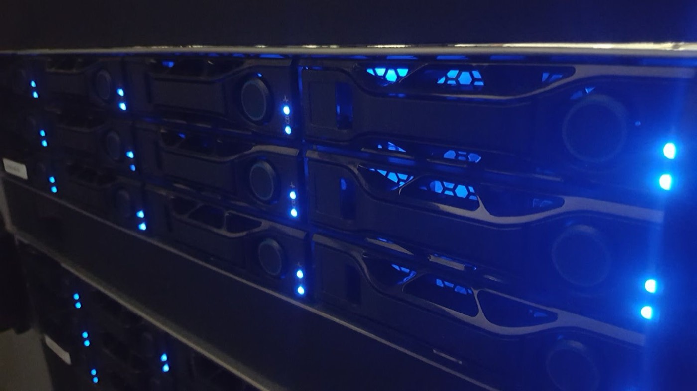 Rows of lit drive bays across stacked servers in a UKNode rack in Manchester.