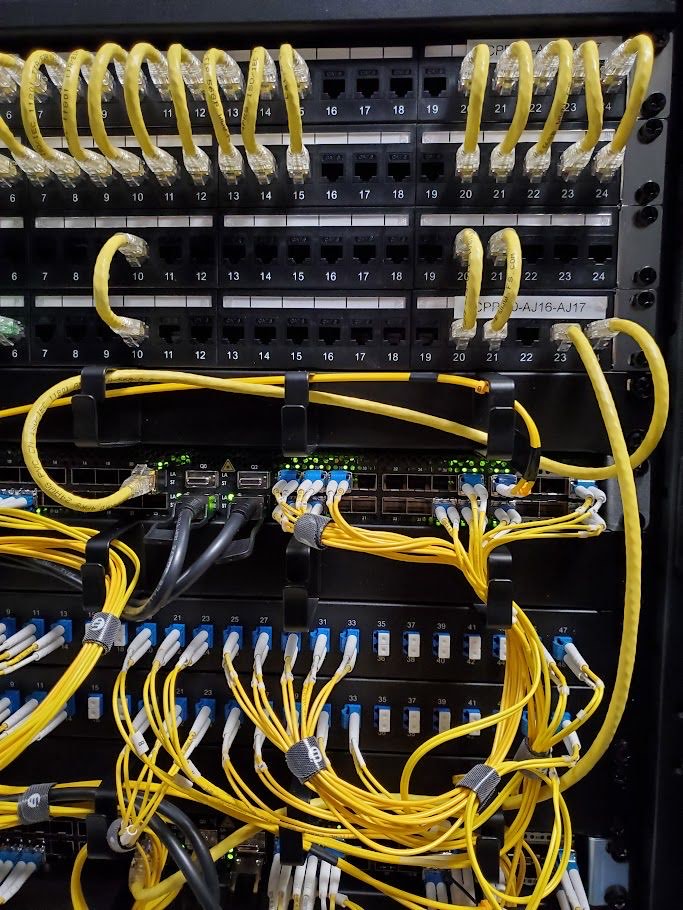 Dense fibre patching into panels and switch uplinks in a UKNode rack in Manchester.